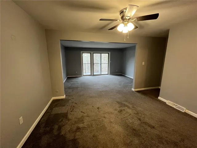 a view of a livingroom with a chandelier fan and a window