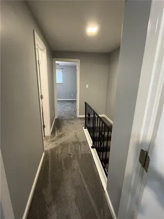 an empty room with a chandelier fan and windows