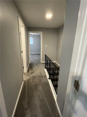 an empty room with a chandelier fan and windows