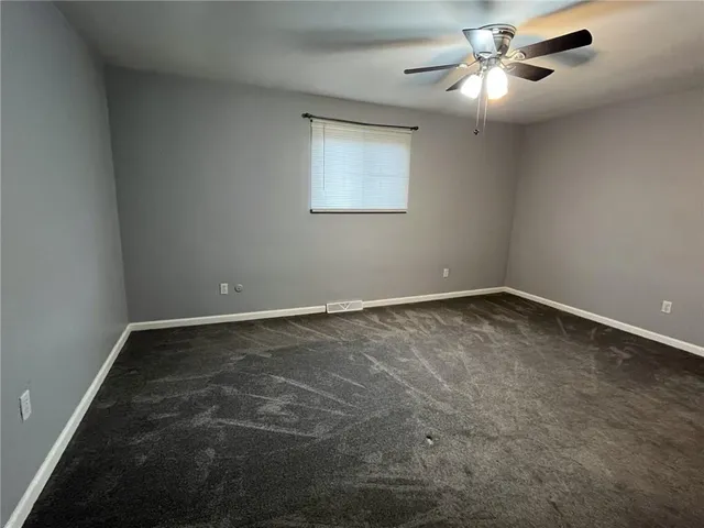 an empty room with fan and windows