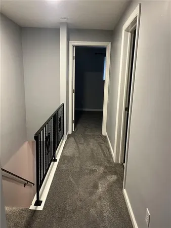 an empty room with a chandelier fan and windows