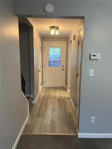 a view of a hallway with wooden floor and a living room