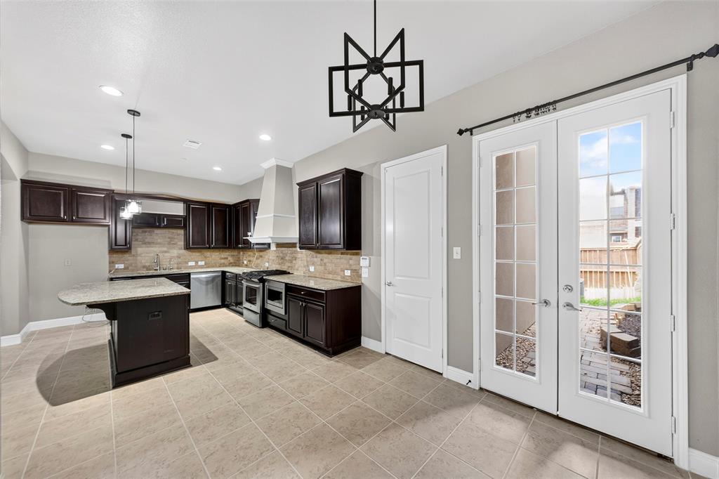 8607 Calvin Road Irving, TX 75063 - Photo 6 of 39 Kitchen featuring dark wood cabinetry, granite countertops, and a full tile backsplash
