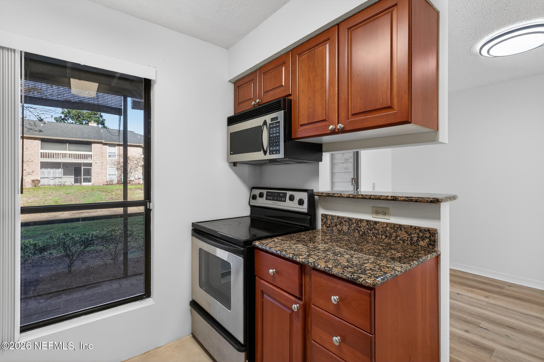 10200 Belle Rive Boulevard, Unit 105 Jacksonville, FL 32256 - Photo 20 of 47 a kitchen with stainless steel appliances granite countertop a stove a microwave and a sink
