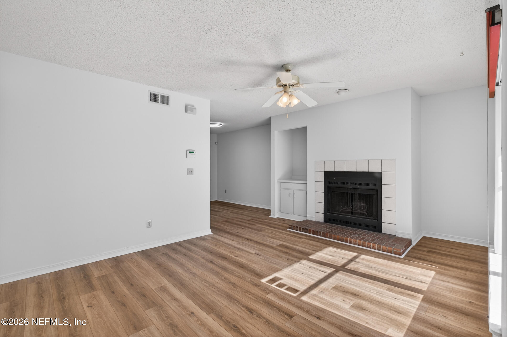 10200 Belle Rive Boulevard, Unit 105 Jacksonville, FL 32256 - Photo 8 of 47 a view of empty room with wooden floor and fireplace