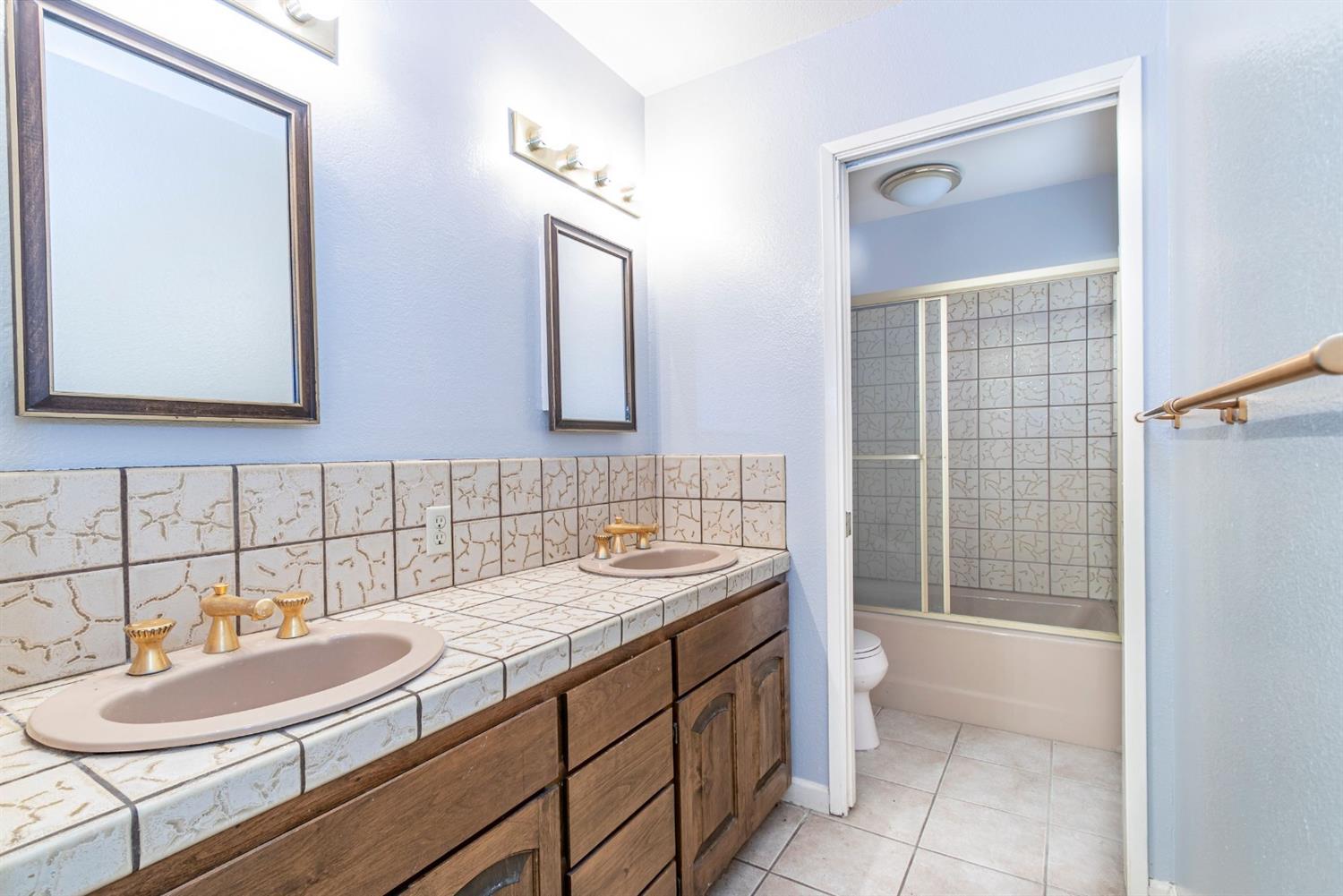 22235 Frontier Road Clovis, CA 93619 - Photo 19 of 31 Hall bath with double sinks and shower over tub.