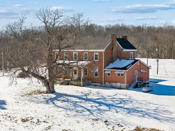 a front view of a house with a yard covered with snow
