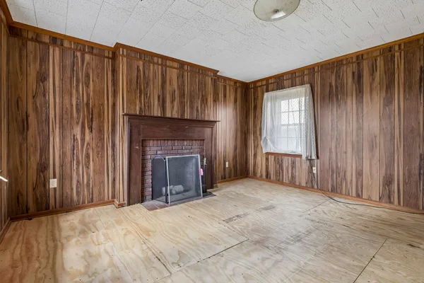 a view of an empty room with a fireplace and a window