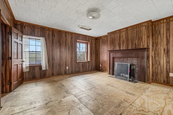 an empty room with windows and a fireplace