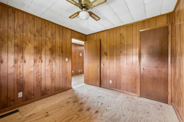 an empty room with windows and a fireplace