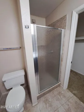 a white toilet sitting next to a shower