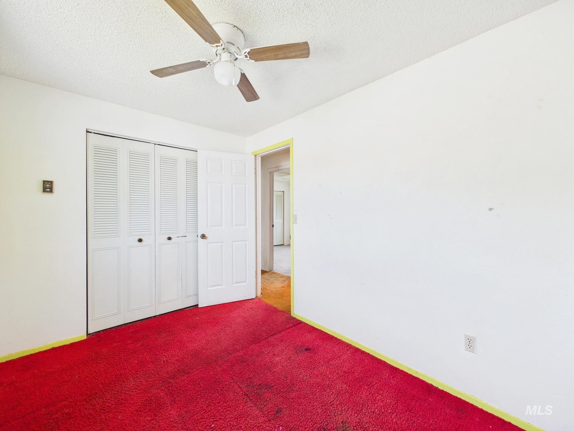 1527 North Plaza Road Emmett, ID 83617 - Photo 25 of 33 Interior room featuring a ceiling fan with wood-finish blades, white textured ceiling, and white walls