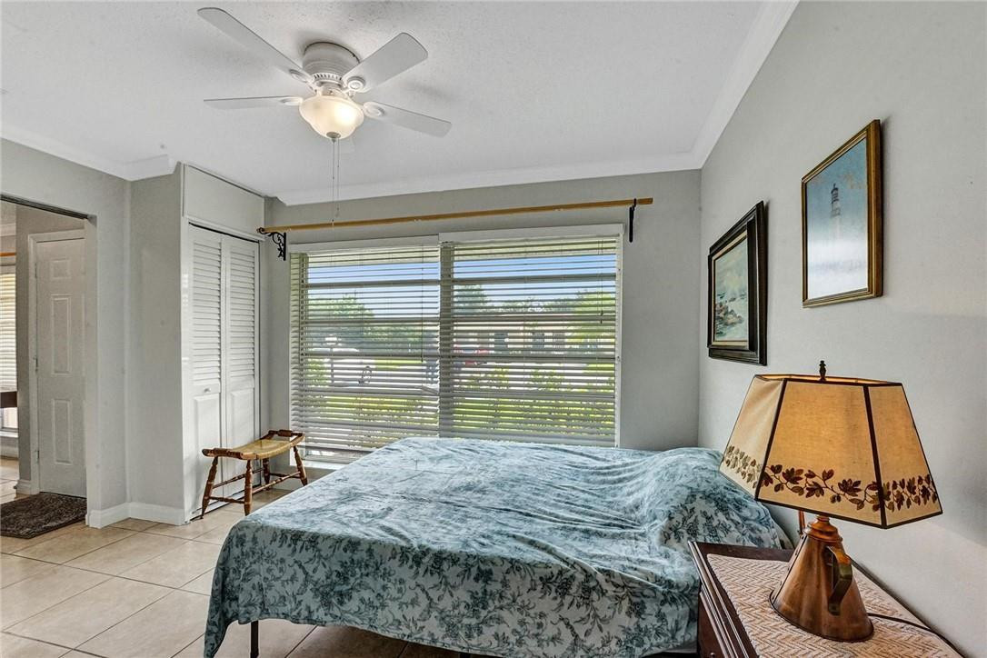 20830 Wendall Terrace, Unit 58 Boca Raton, FL 33433 - Photo 7 of 27 a bedroom with a bed and a chandelier
