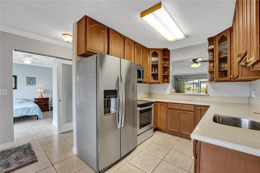20830 Wendall Terrace, Unit 58 Boca Raton, FL 33433 - Photo 9 of 27 a kitchen with stainless steel appliances granite countertop a refrigerator and a sink