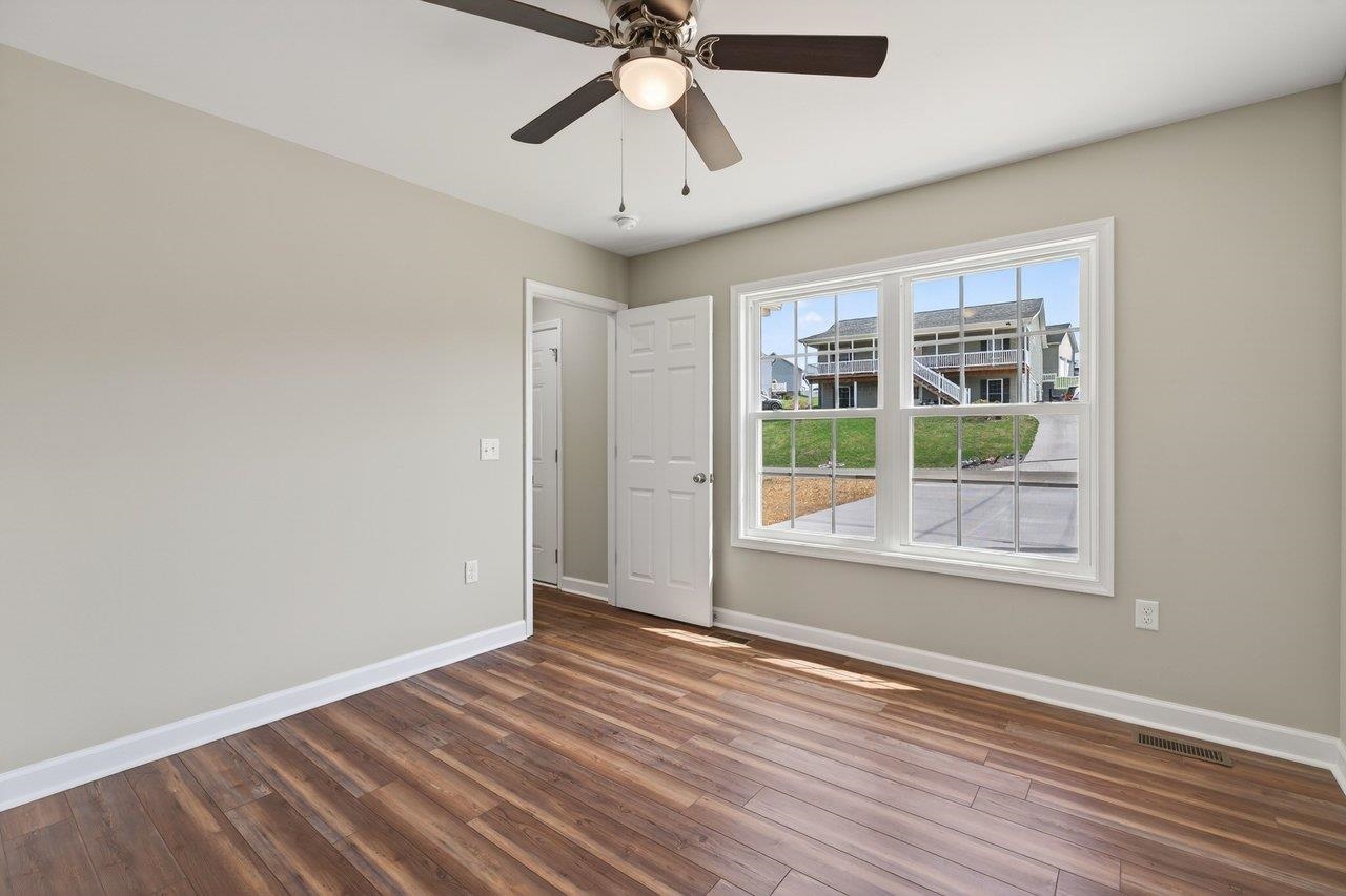 254 Locustdale Loop Shenandoah, VA 22849 - Photo 36 of 58 an empty room with wooden floor chandelier and windows