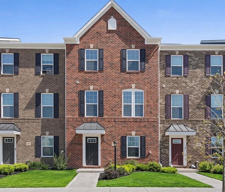 a front view of a brick house with a yard