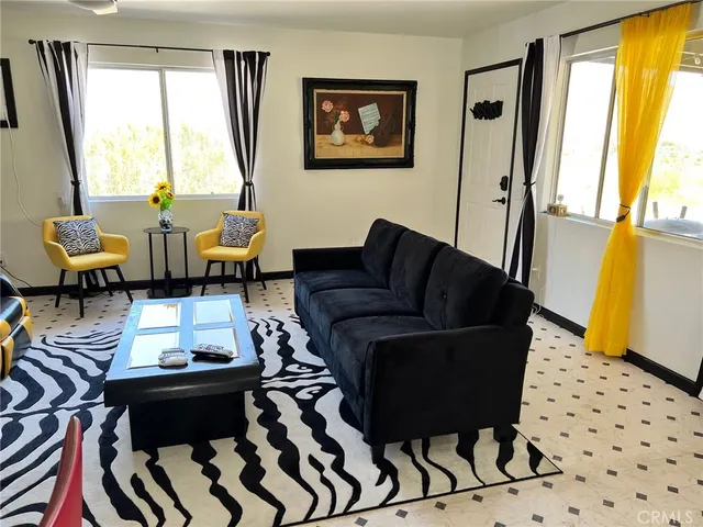 a living room with furniture kitchen view and a window