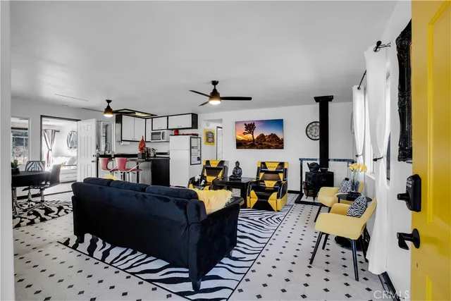 a living room with furniture kitchen view and a window
