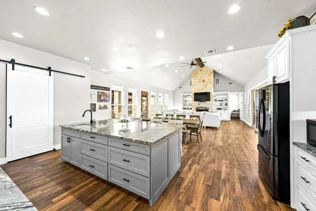 a large kitchen with lots of counter top space a sink a window and stainless steel appliances