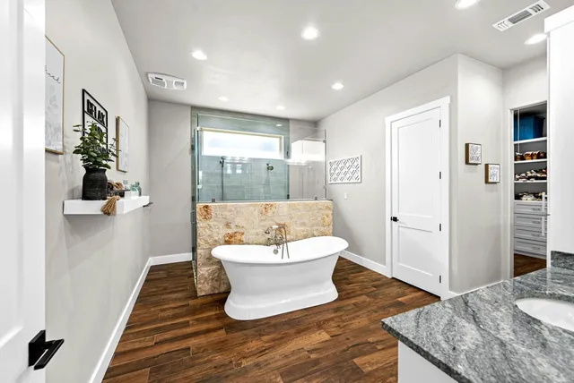 a spacious bathroom with a granite countertop sink and a large mirror