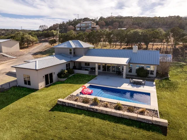 a view of a house with swimming pool and furniture