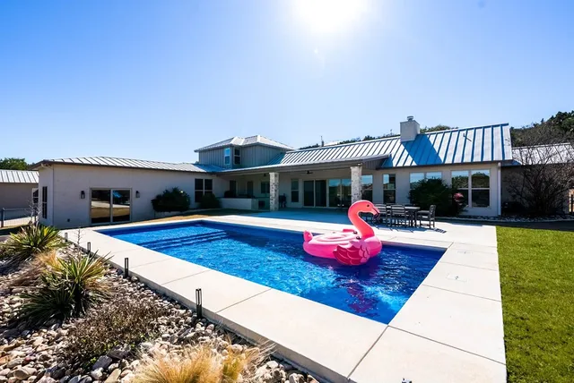 a view of a lake with a floor to ceiling window next to a yard
