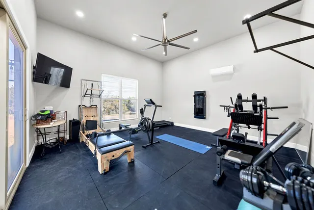 a living room with furniture flat screen tv and a ceiling fan