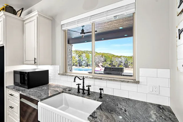 a kitchen with kitchen island granite countertop a sink appliances and a counter top space
