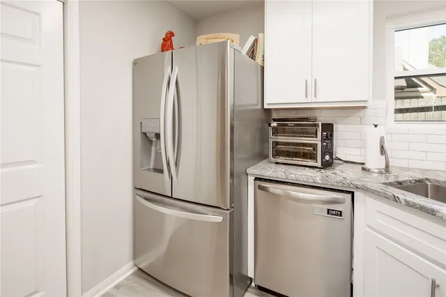 a kitchen with stainless steel appliances granite countertop a refrigerator and a sink