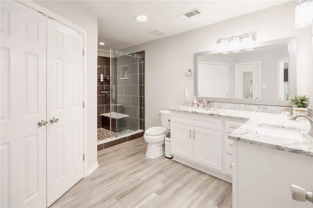 a bathroom with a granite countertop sink a toilet and shower