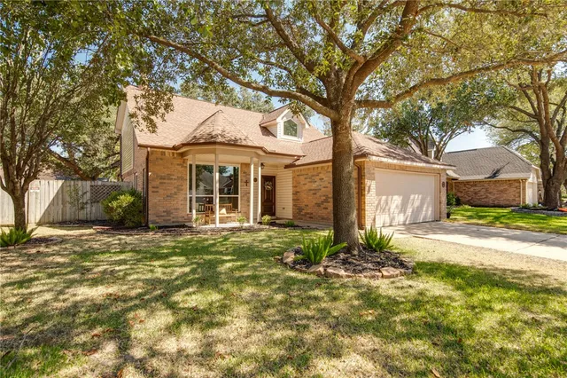 a front view of a house with a garden and trees