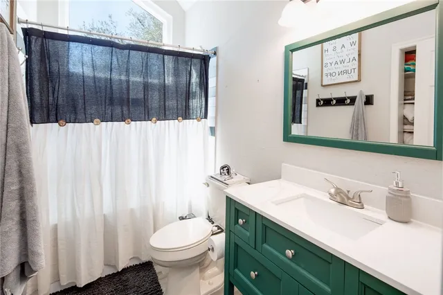 a bathroom with a sink vanity mirror and toilet