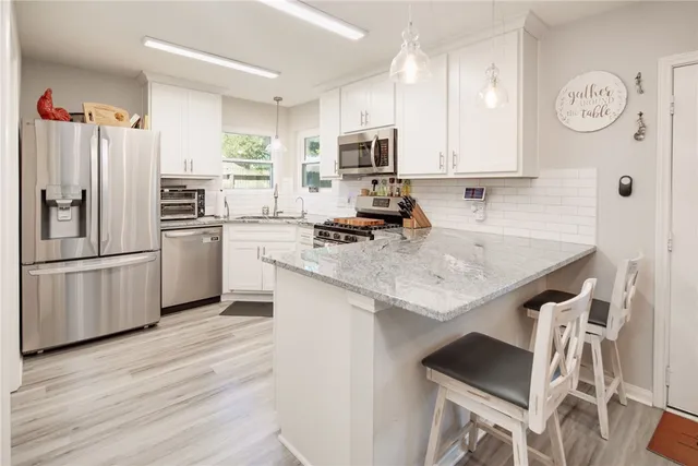 a kitchen with granite countertop stainless steel appliances and wooden cabinets