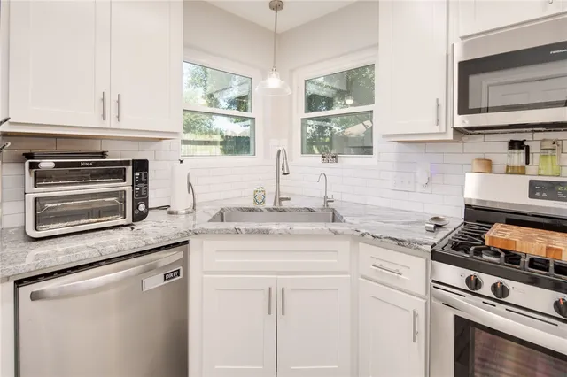 a kitchen with appliances cabinets and a window