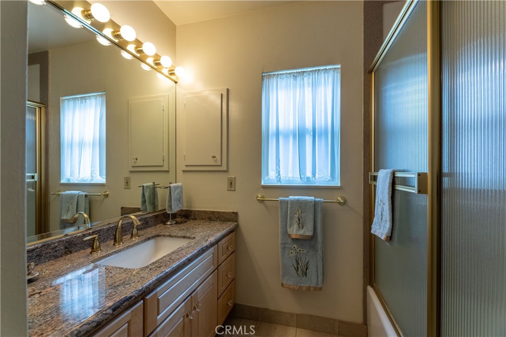 1401 Hackett Avenue Long Beach, CA 90815 - Photo 32 of 48 a bathroom with a granite countertop sink and a mirror