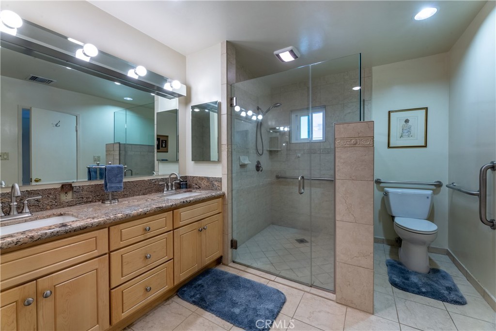 1401 Hackett Avenue Long Beach, CA 90815 - Photo 39 of 48 a bathroom with a granite countertop sink a toilet a mirror and shower
