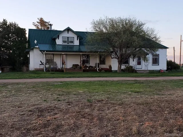 a view of a big house with a big yard and large trees