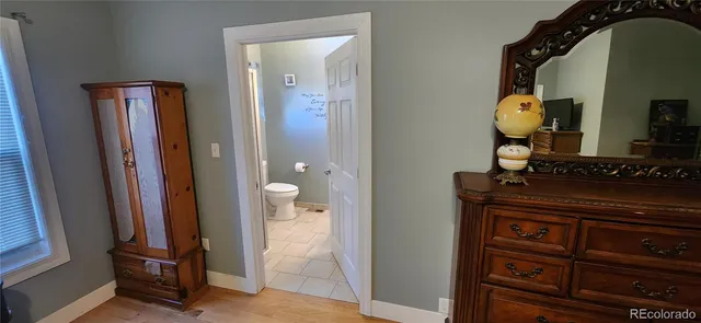 a bedroom with bed and wooden floor