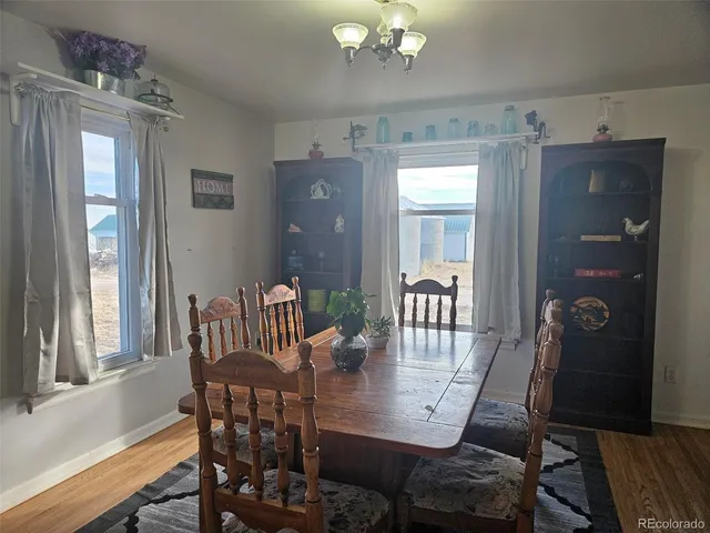 a kitchen with stainless steel appliances a refrigerator a sink a stove a table and chairs