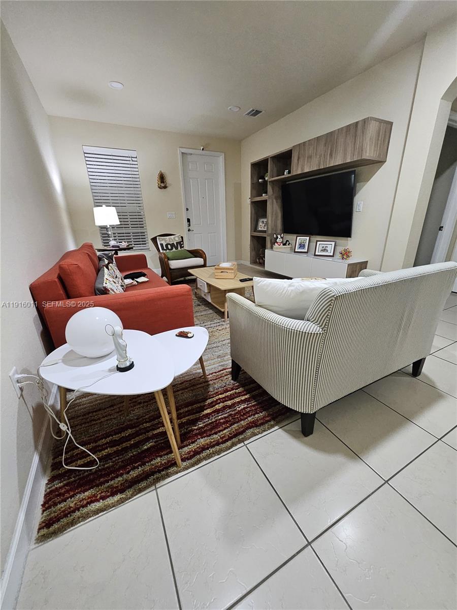 9572 Southwest 169th Place Miami, FL 33196 - Photo 4 of 14 a living room with furniture and a flat screen tv