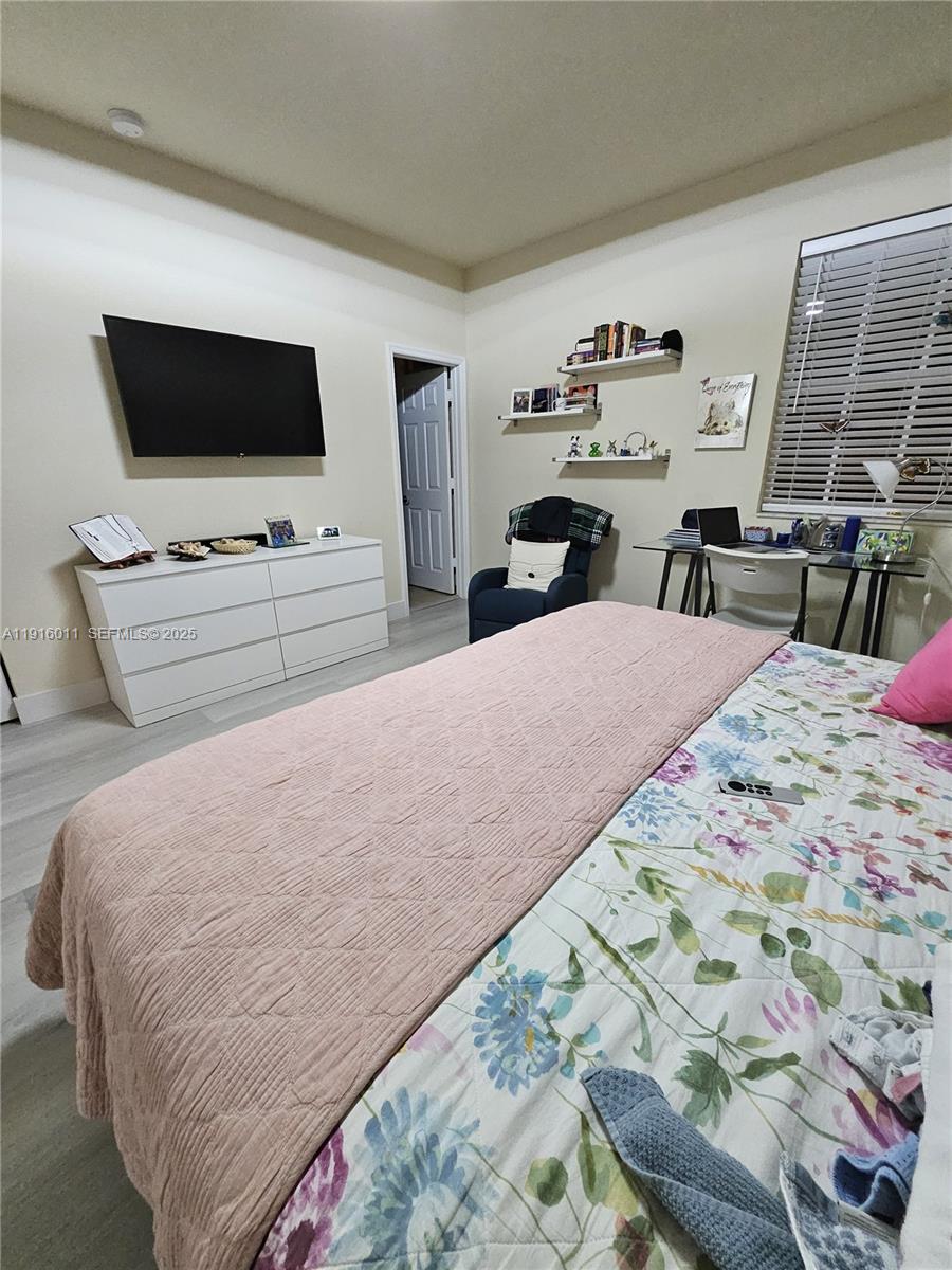 9572 Southwest 169th Place Miami, FL 33196 - Photo 8 of 14 a bedroom with a bed and a flat screen tv