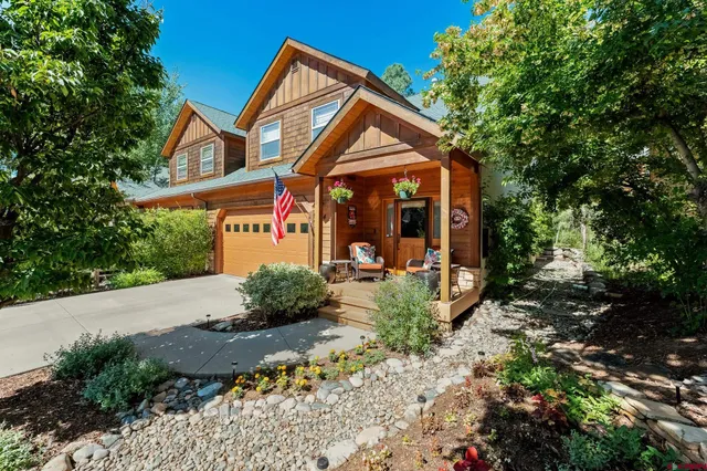 a view of a house with backyard and trees