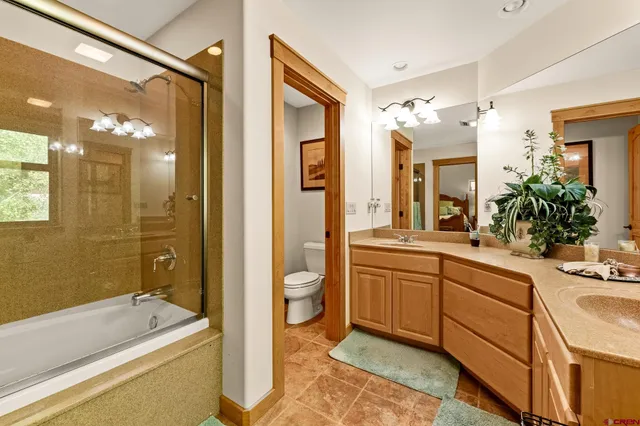 a spacious bathroom with a granite countertop sink mirror and a bathtub