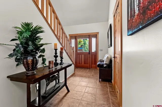 a view of a hallway with couches and potted plants with wooden floor