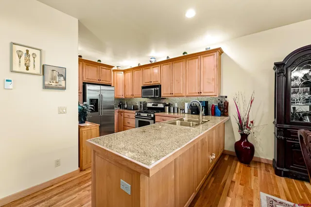 a kitchen with a sink a counter top space stainless steel appliances and cabinets