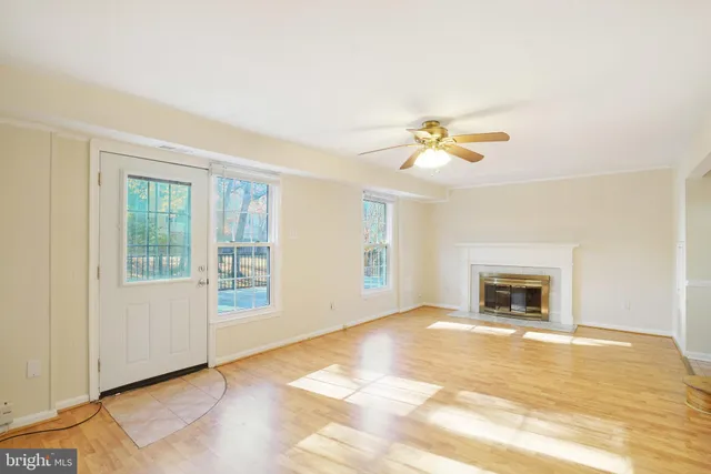 a view of an empty room with a fireplace and a window