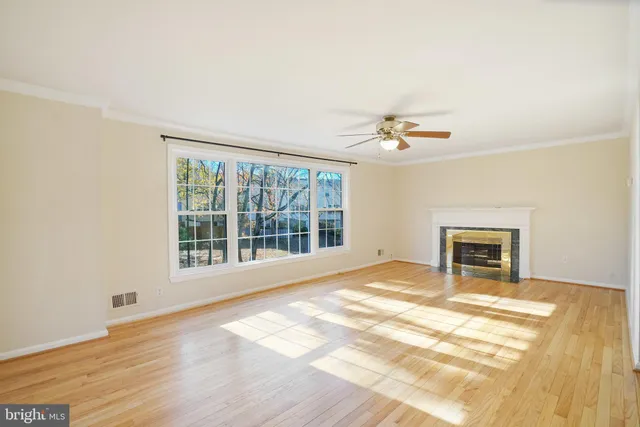 a view of a room with wooden floor and a ceiling fan
