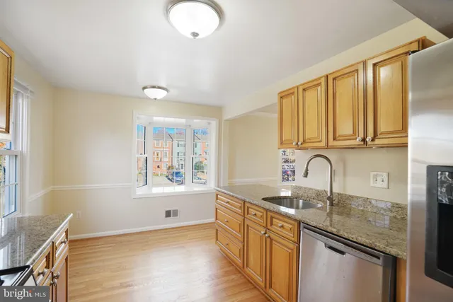 an empty room with wooden floor ceiling fan and windows