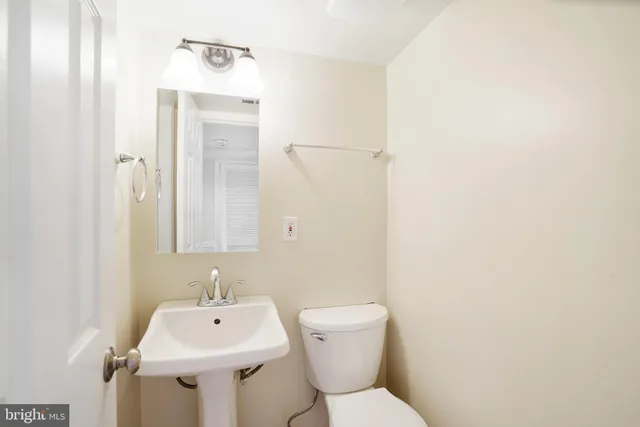 a bathroom with a sink toilet and a mirror