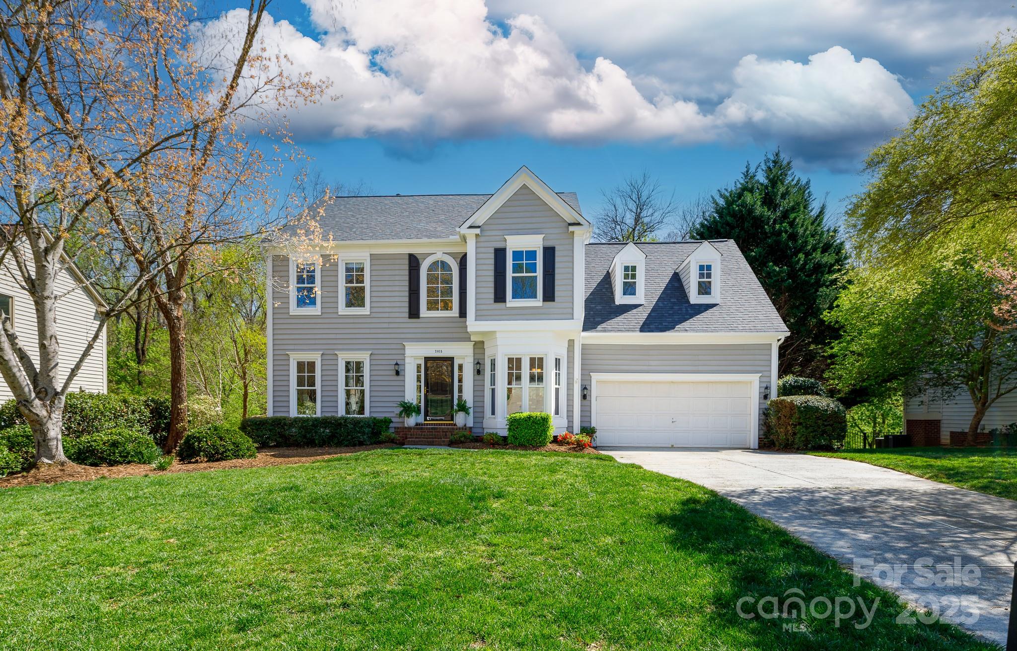 2815 Providence Spring Lane Charlotte, NC 28270 - Photo 1 of 42 a front view of a house with a garden and plants